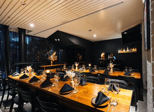 Dramatic Candlelit Dining Space With Dark Elegance and Luxe Wood Finishes