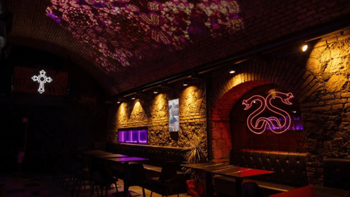 Bold Neon Art Bar With Exposed Brick and Floral Projections for Eclectic Parties