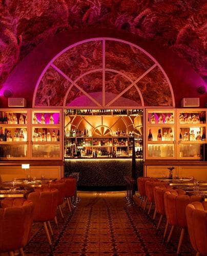 Vibrant Venue With Artistic Ceilings and Bold Pink Lighting for Cocktails