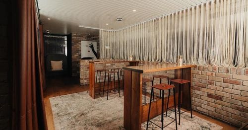 Eclectic Attic With Brick Walls and String Curtains for Private and Casual Dinners