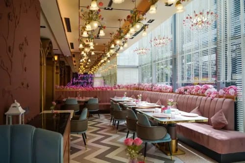 Maximalist Art Deco Pink Café With Immersive Floral Ceilings and Neon-Signed Alcoves for Vibrant Private Gatherings