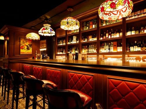 Lavish Mahogany Bar With Stained-Glass Glow for Luxe Private Gatherings