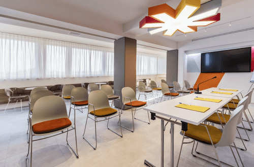 Skyline-Facing Boardroom With Starburst Ceiling Light and Geometric Wall