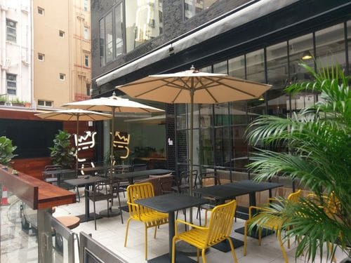 Modern Outdoor Terrace With Glass Façade and Lush Greenery for Team-Building Sessions