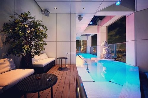 Sleek Rooftop Lounge With Illuminated Pool and Skyline Views for Intimate Soirées