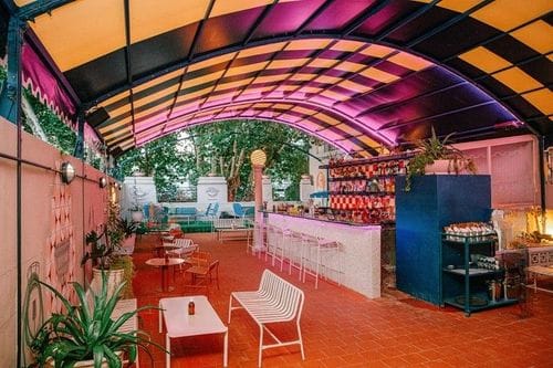 Retro Hidden Bar With Neon Rooftop Terrace and Vaulted Ceiling for After-Works