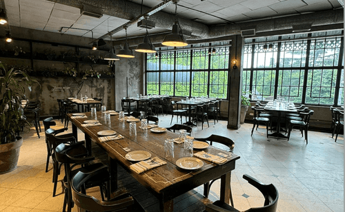Industrial-Chic Dining Setting With Floor-To-Ceiling Windows and Urban Ambience